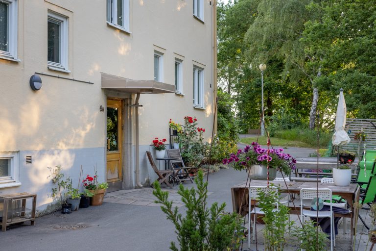 En uteplats med bord och stolar utanför en byggnad.