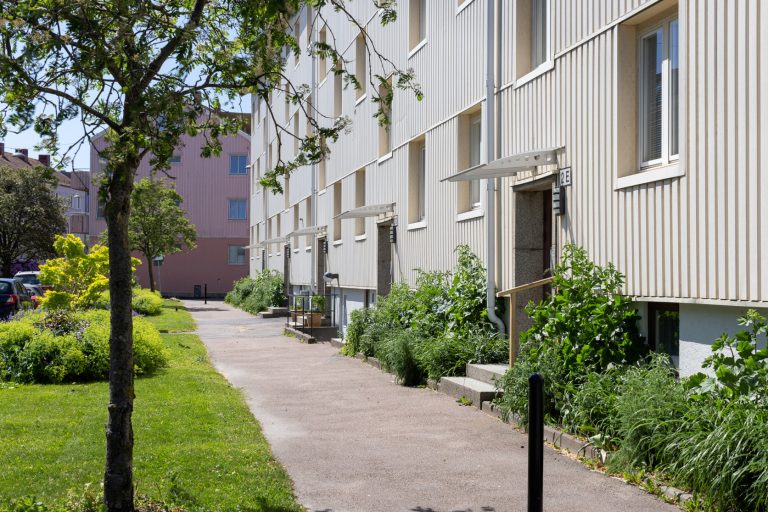 En trottoar bredvid en rad byggnader.