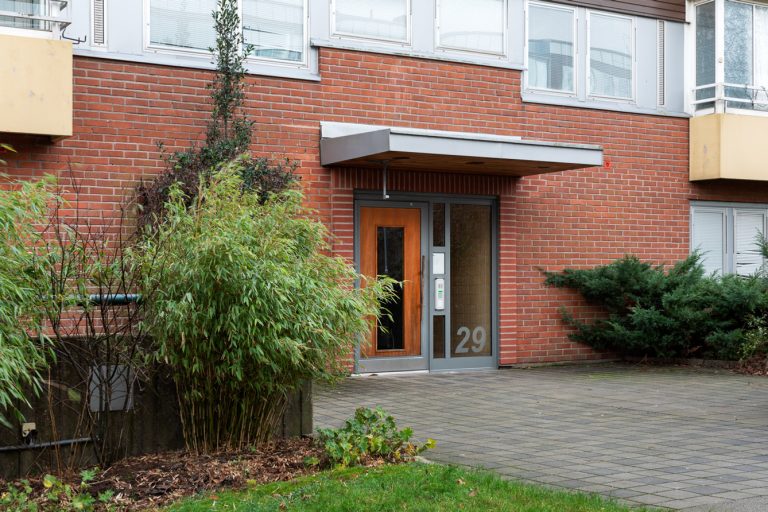 En röd tegelbyggnad med en brun dörr.