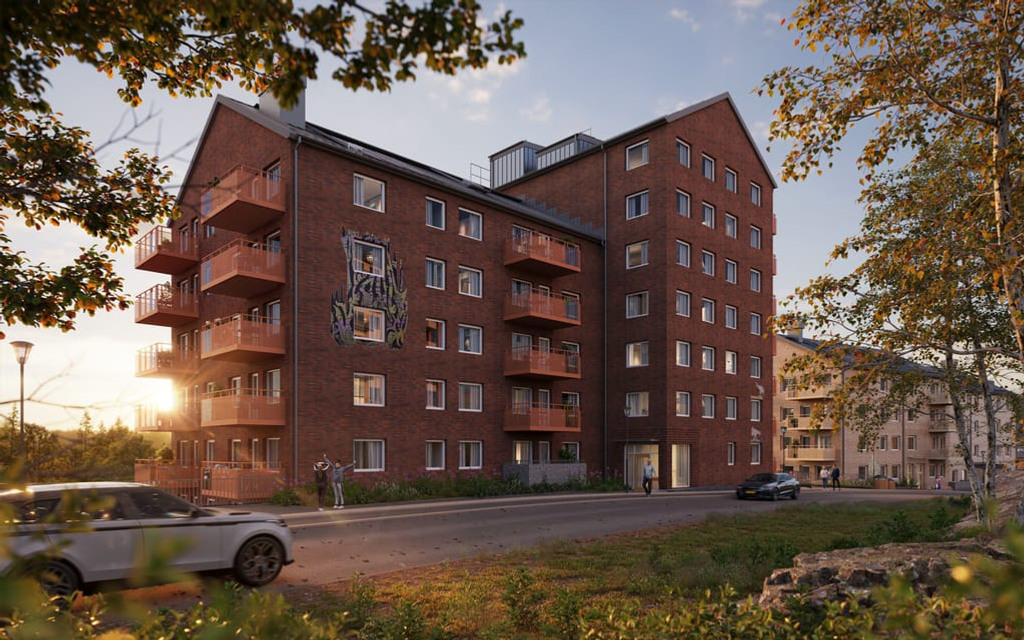 En visualiseringsbild över ett hyreshus i rött tegel med parkerade bilar, grönska och trottoar framför.