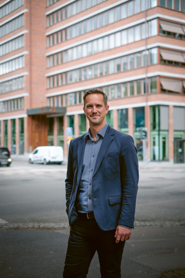 En man som står framför en hög byggnad.