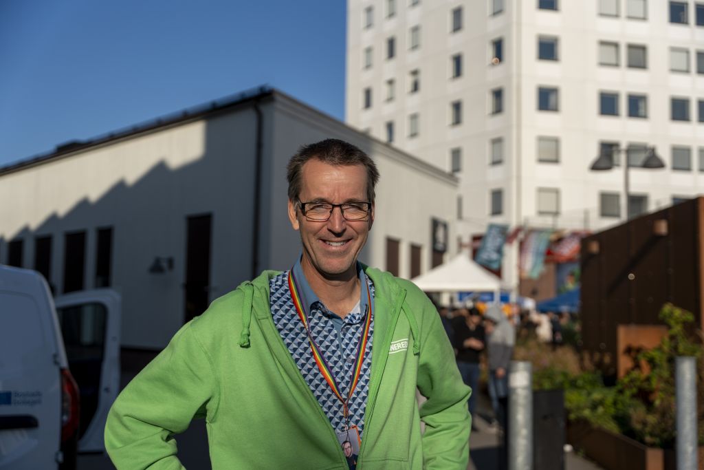 Pontus Berger står i grön Destination Tynnered-tröja framför höghus.