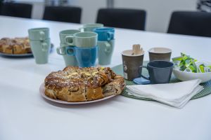 Kaffekoppar och ett fat med bullar på ett bord.