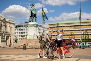 Ett par med cyklar tar en selfie på Gustav Adolfs torg.