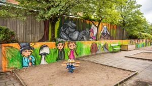 Bilden föreställer målade troll på en mur till en lekplats i Tynnered.