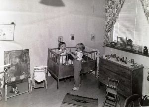 Två syskon leker i sitt rum i Norra Biskopsgården 1959.
