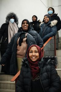 En grupp kvinnor i en trappa ler in i kameran.