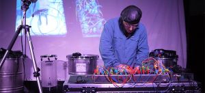 En man med skinnkeps skapar musik med elektronik.