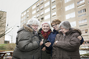 Fyra kvinnor möts framför höghus