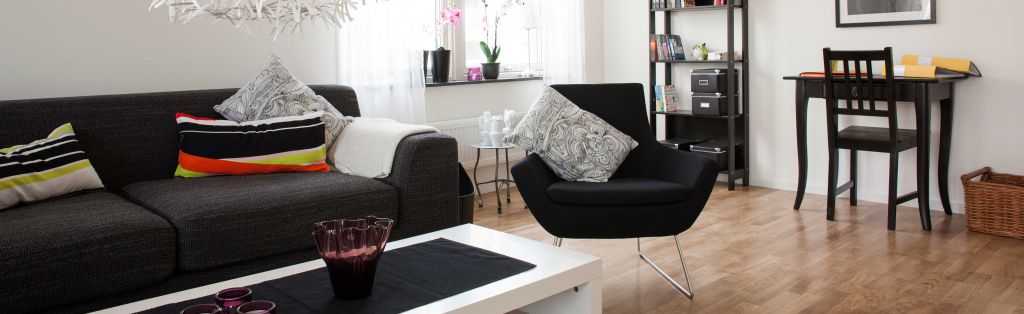 Ett vardagsrum med soffa, bord och stolar